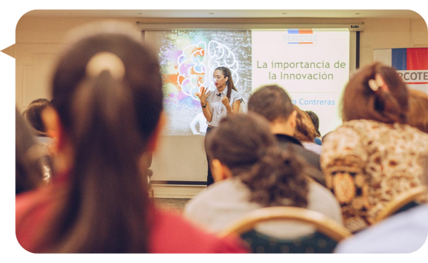 Bárbara Contreras dando una presentación sobre innovación frente a una audiencia en una sala de conferencias.