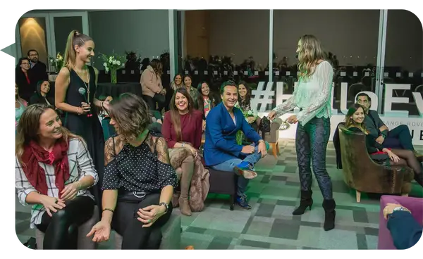 Angélica Castro, conferencista internacional, interactuando con la audiencia durante un evento de Land Rover, destacando su enfoque participativo y motivacional.