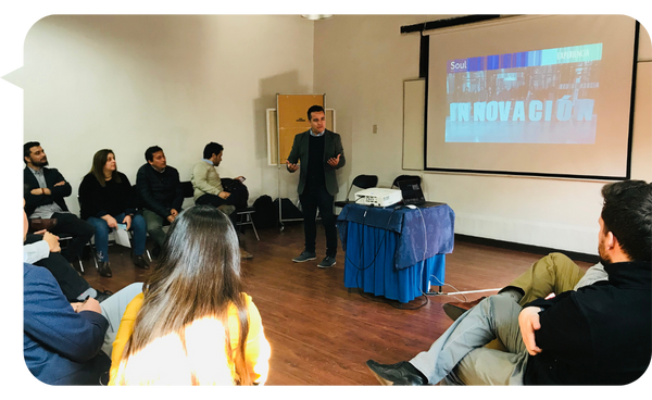 Julián Mendiola dando una presentación sobre innovación frente a un grupo de participantes en una sala de reuniones.