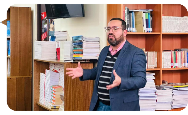 Óscar Alarcón dando una charla en una biblioteca, hablando apasionadamente sobre la prevención de adicciones.