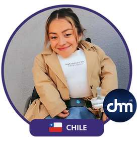 Camila Herrera, oradora motivacional y activista chilena, sonríe en una silla de ruedas mientras lleva un abrigo beige, una camiseta blanca y un fondo gris, con un diseño circular y el logotipo de CHM.